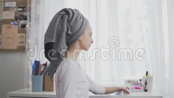 美丽的健康女人在毛巾上放保湿霜视频的预览图