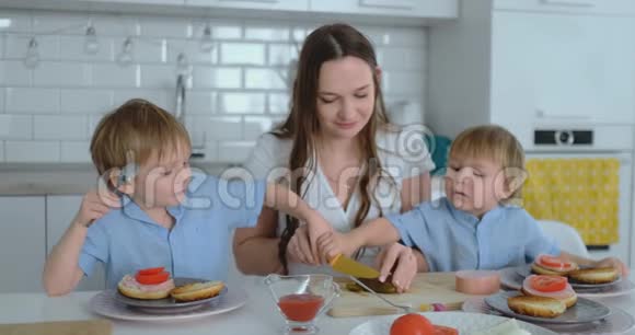 美丽的年轻母亲有两个孩子两个孩子一个是白光一个是汉堡视频的预览图