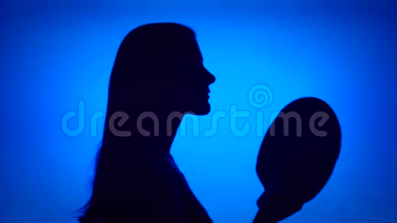 女人的剪影戴在头上女性的面部轮廓蓝色背景的头饰视频的预览图
