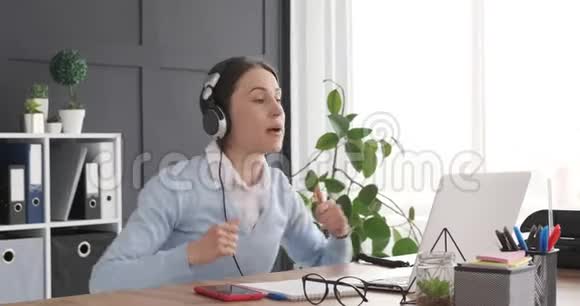 女人在工作场所一边听音乐一边唱歌视频的预览图