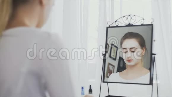 女人在镜子前把面罩戴在脸上视频的预览图