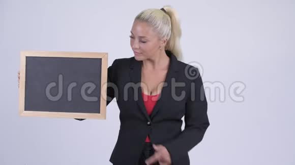 年轻快乐的金发女商人拿着黑板竖起大拇指视频的预览图