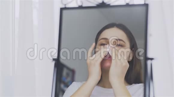 年轻女子在镜子前用棉垫洗脸视频的预览图