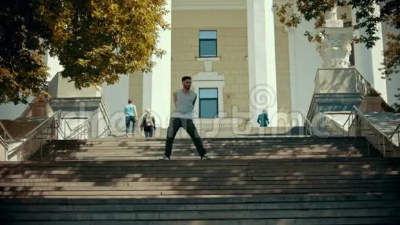 年轻时尚的男子在楼梯上跳舞背景是一栋建筑视频的预览图