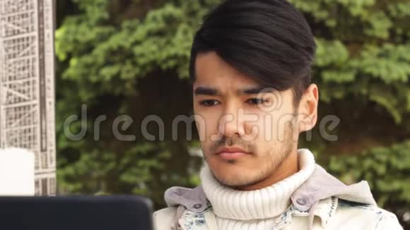 亚洲学生男子手提电脑相机微笑视频的预览图