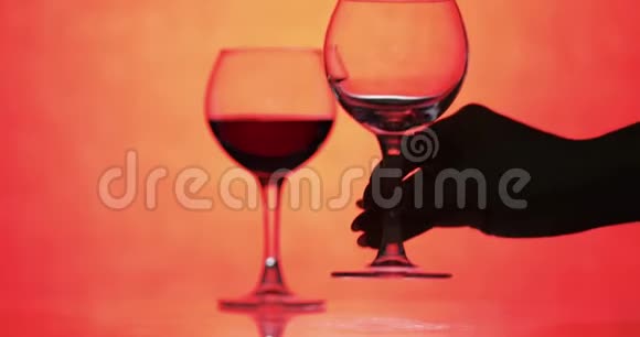 玫瑰酒红酒倒入橙色背景的酒杯视频的预览图