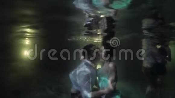 年轻可爱的夫妇晚上在游泳池里拥抱和亲吻浪漫的约会热带地区的假期视频的预览图
