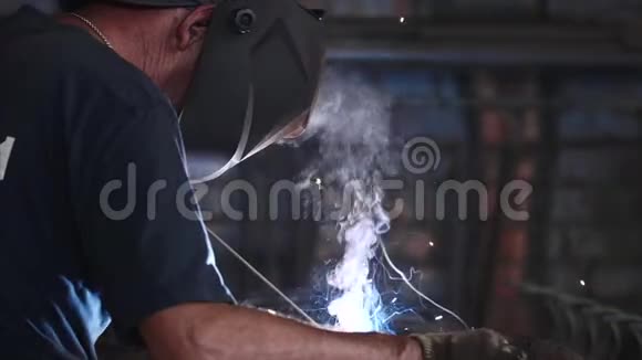 防护面罩中的焊工使金属在缓慢运动中进行电弧焊接视频的预览图