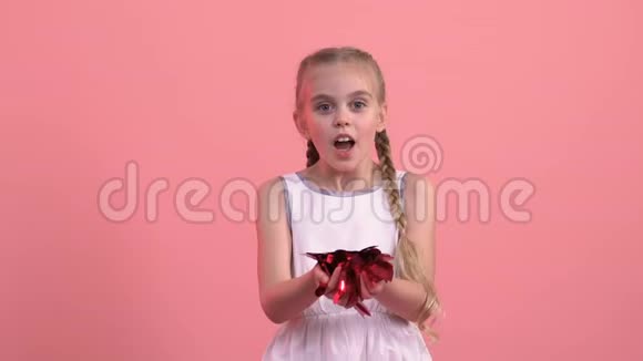 微笑的女孩从手中吹出心形纸屑圣瓦伦丁节节日视频的预览图