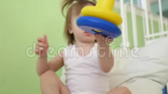 小宝宝正坐在医院病房的床上玩玩具生病的女孩在医院里康复视频的预览图