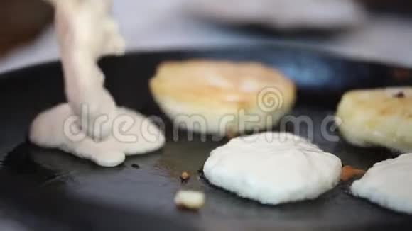 一个人用厚厚的面团在旧锅里做煎饼视频的预览图