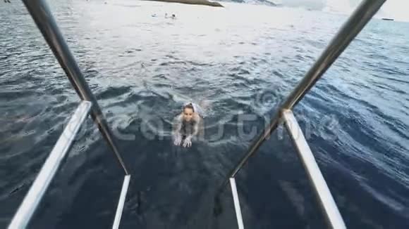 美丽苗条性感快乐的女士穿着蓝色泳装在炎热的山湖里放松游泳和享受淡水视频的预览图