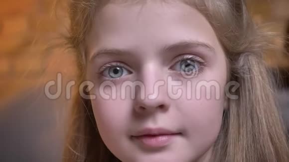 在舒适的家庭氛围中小可爱的白种人女孩微笑着进入镜头的特写肖像视频的预览图