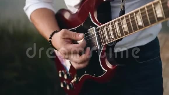 他在码头上弹吉他手的特写视频的预览图