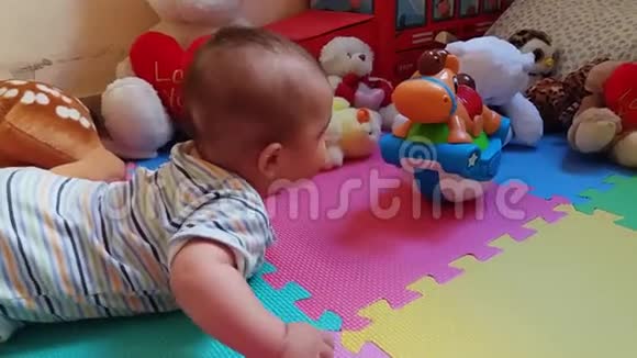 可爱的小男孩在他的肚子试图接触玩具视频的预览图