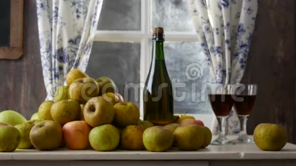 移动相机滑块显示瓶子和眼镜苹果酒在乡下的房子里视频的预览图