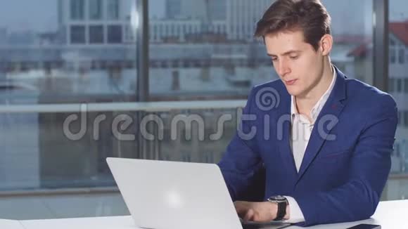 现代有吸引力的商人用笔记本电脑在办公桌上工作的画像视频的预览图