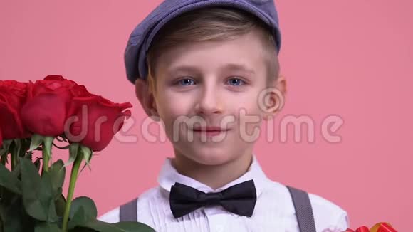 带着玫瑰花束和礼品盒准备约会的小男孩情人节视频的预览图