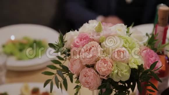 喜庆的餐桌上放着美丽的婚礼花束视频的预览图