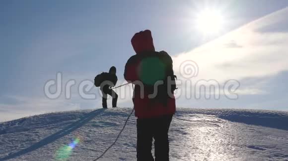 一群商业人士登上了他们成功的顶峰团队合作的商人三个登山者在雪地上爬绳视频的预览图