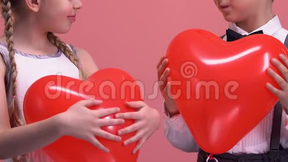 快乐的小夫妻手里拿着心形的气球对着镜头微笑爱视频的预览图