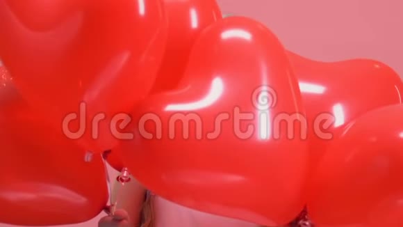 美丽的小女孩出现在红色气球后情人节惊喜视频的预览图