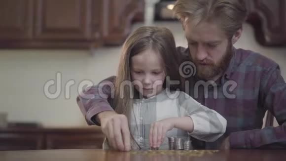 有胡子的男人坐在厨房的桌子旁女儿在数钱穿格子衬衫的胡子视频的预览图
