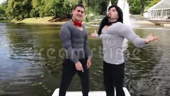两个穿着假肌肉垫服的滑稽青年在船上跳舞视频的预览图