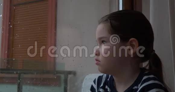 雨天一个小女孩坐在窗边视频的预览图