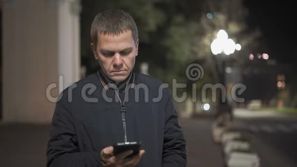 夜城中站着一部智能手机发出的严肃的呼唤特写视频的预览图