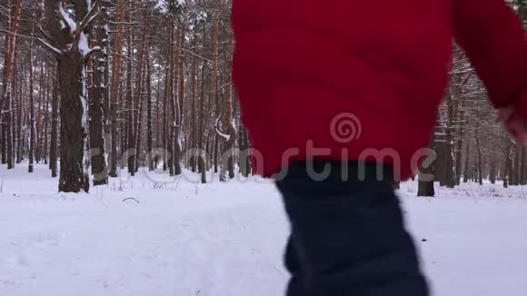 孩子们爸爸妈妈在冬天的雪林里奔跑笑有女儿的男人和女人一起在公园玩视频的预览图