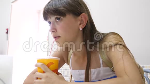 咖啡馆里的女孩用吸管喝鸡尾酒视频的预览图