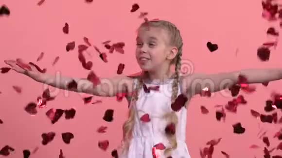 兴奋的女孩享受从天而降的心形纸屑节日庆典视频的预览图