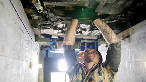 汽车服务有纹身的机械师站在检查坑里用工具工作视频的预览图