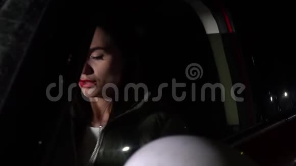 美丽的女人坐在车里环顾四周晚上闭上眼睛视频的预览图