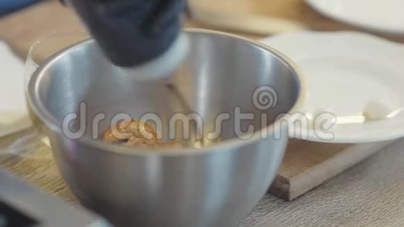 金虾在小金属碗里倒着酱汁就近了厨师用调料倒菜视频的预览图