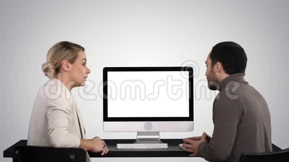 商务人士在电脑显示器周围开会谈论梯度背景下屏幕上的内容视频的预览图
