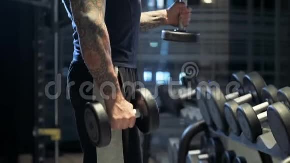 一个手拿哑铃弯曲手臂的家伙在健身房锻炼视频的预览图