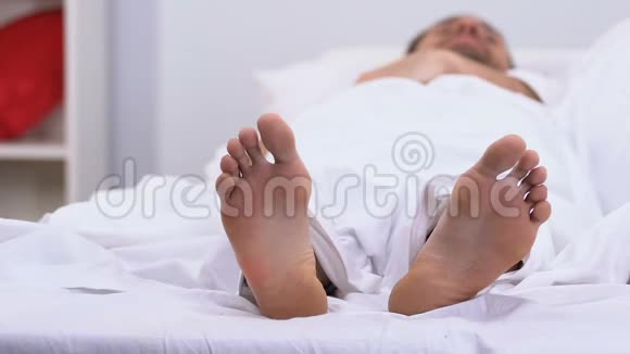 男人抚摸愤怒的女人的脚早上在床上吵架婚姻问题视频的预览图