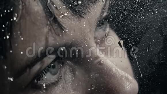 玻璃后面一个带水滴的女孩的肖像视频的预览图