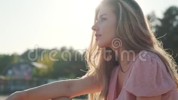 迷人的年轻女子坐在沙滩上视频的预览图