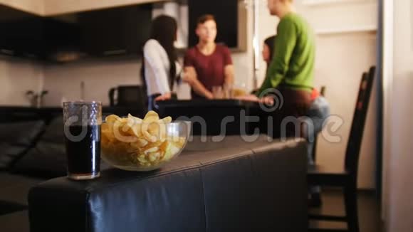 一群年轻朋友一起站在厨房里碗里装满了前台的芯片视频的预览图