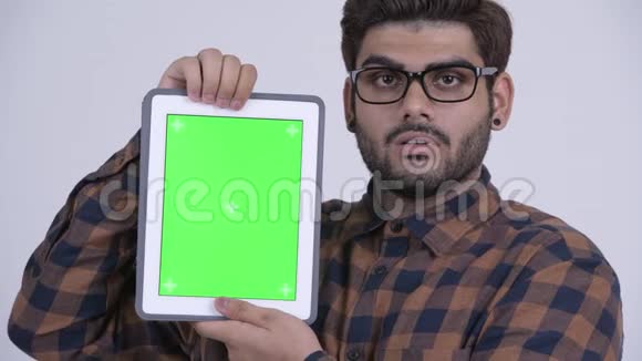 一位年轻的留胡子的印度时髦男人展示数码平板电脑视频的预览图