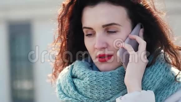 有卷发的女孩在街上打电话她看起来对电话不高兴视频的预览图