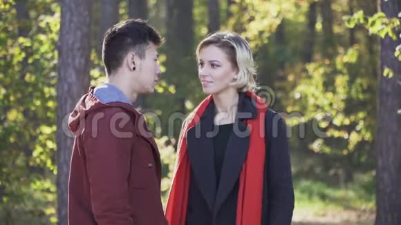 一个漂亮的年轻顽皮的女孩穿着一件外套和一条红领巾金发碧眼在森林里逃离了她的男朋友这就是视频的预览图
