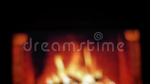 近距离后景拍摄双手拿着一杯红酒在舒适温暖的壁炉上做一个嗅探器视频的预览图