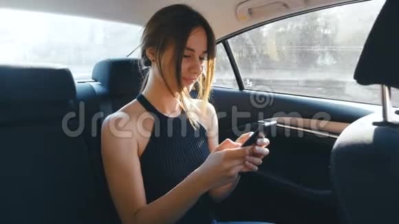 年轻女子在开车时使用她的智能手机女孩在骑车的时候检查指甲视频的预览图