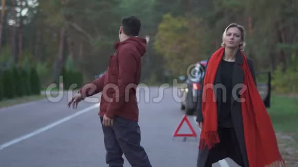 英俊的亚洲男人举起拇指去抓一辆车人试图在路上拦住一辆车但车开着青年视频的预览图