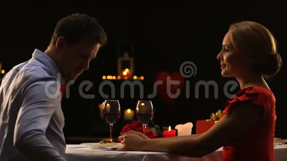 在情人节当天男士送给穿着红色连衣裙的漂亮女士珍贵的礼物视频的预览图