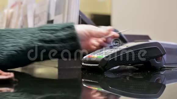 特写终端读卡器进行刷卡支付一个女人她的手是用信用卡付款的视频的预览图